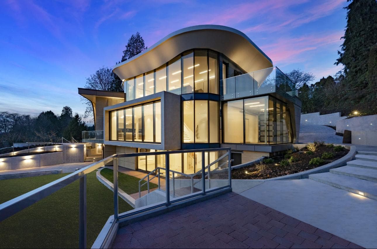 Modern hillside home at twilight with curved architecture, terraced concrete steps, and retaining walls by MZ Solution